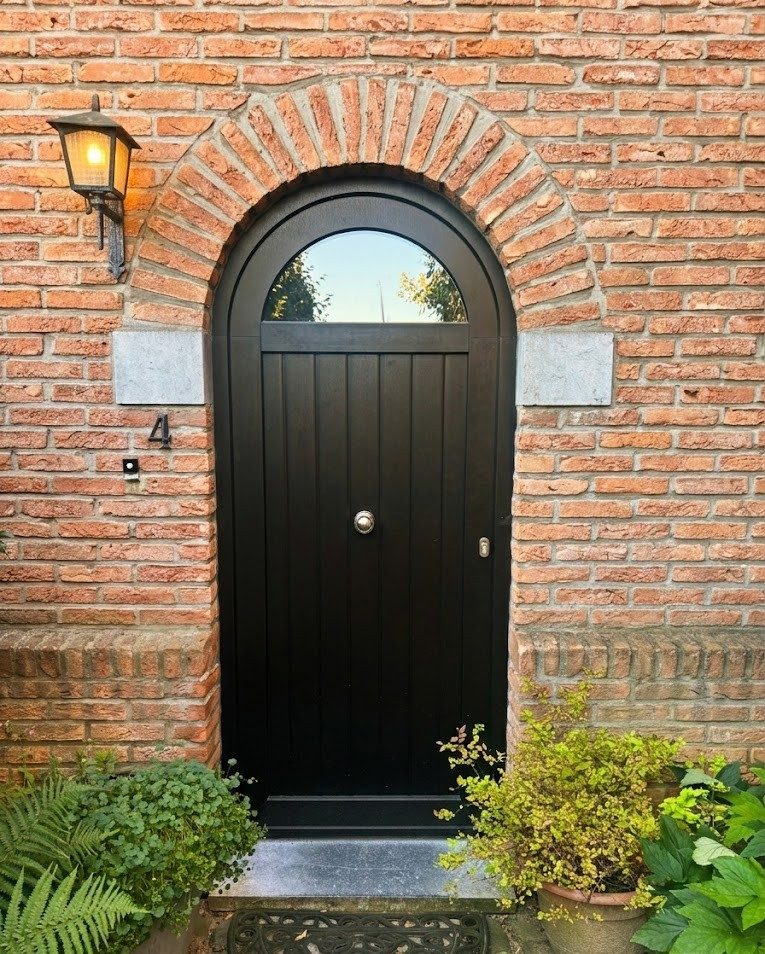 Porte cintrée noire en maison de maître